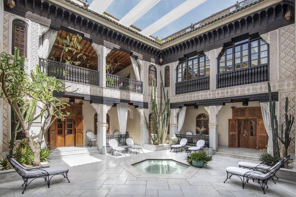 Marrakech luxury riad lobby with intricate Moroccan architecture and vibrant mosaics